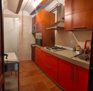 a kitchen with red cabinets and a stove at Casa Rural María in Los Alagones