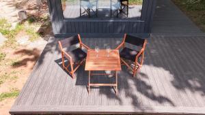 two chairs and a wooden table on a deck at Ginger Cabins in Žabljak
