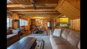 a living room with a couch and a table in a cabin at Blue Springs Pond Cabin - Near Yellowstone - Hot Tub in Island Park