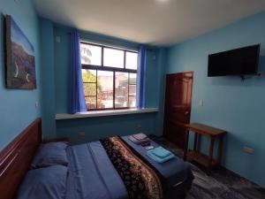 プエルト・バケリソ・モレノにあるCasa Cypress - Acogedor Departamento Vacacionalのベッドルーム(ベッド1台、窓、テレビ付)
