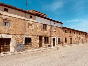 un vieux bâtiment en briques au bord d'une rue dans l'établissement Villa Alicia-Casa Rural, 