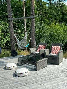 two chairs and a hammock on a patio at Forest Cabin By The Sea Near Fredrikstad in Kråkerøy