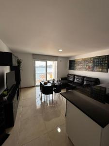 a kitchen and living room with a table and chairs at Vila do Ilhéu in Vila Franca do Campo