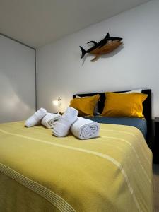 a bedroom with a bed with towels and a fish on the wall at Vila do Ilhéu in Vila Franca do Campo