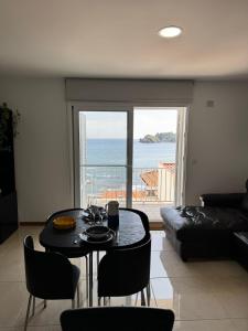 a living room with a table and a view of the ocean at Vila do Ilhéu in Vila Franca do Campo