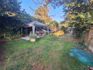 a backyard with a gazebo and a picnic table at CABIN in hosts huge garden CHILD FRIENDLY with Hens Kittens firepit Marshmallows in Charing