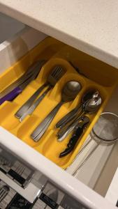 a yellow tray with utensils in a drawer at Empire M in Kinshasa