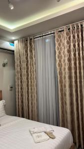 a bedroom with a bed and curtains in a room at Empire M in Kinshasa