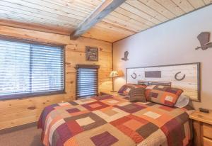 a bedroom with a large bed in a wooden room at Rustic Cabin Retreat - Hot tub - Fire pit - BBQ - in Island Park