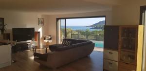 サン・ラファエルにあるArchitect-designed villa, overlooking Agay Bayのソファがあり海が見えるリビングルーム