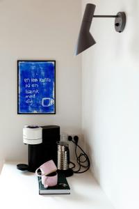 a room with a table with a blender and a lamp at Newly Built Summer House With Sea View in Haderslev