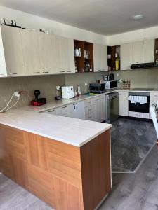 a kitchen with white cabinets and a counter top at The Byala Escape, Private Villa with Bar & Hot Tub in Byala