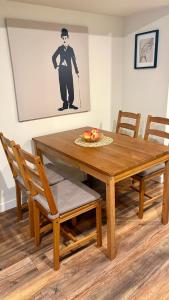 een houten eettafel met stoelen en een afbeelding van een heer bij Private Apartment Where Remote Work Meets Real Comfort in Oakville +20 foto's