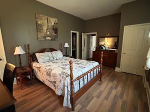 a bedroom with a large bed with a wooden floor at Graystone Manor in Albion