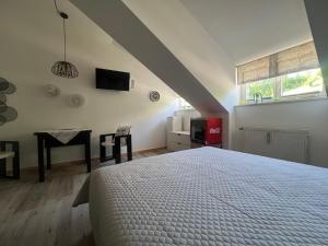 Un dormitorio con una cama y una mesa y una ventana. en ciao-aschau Haus zur Burg Ap311, en Aschau im Chiemgau