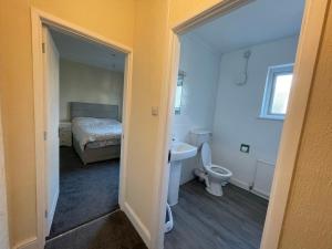 a bathroom with a bed and a toilet and a sink at Ouse River Quay Hill Lodge in Littleport +14 photos