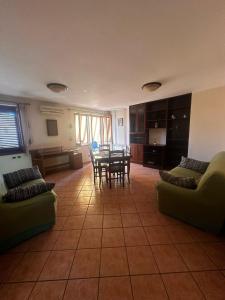 un ampio soggiorno con tavolo e sedie di Appartamento Franca a Capo dʼOrlando