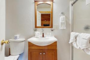 Un baño con lavabo, inodoro y espejo. en Hatcher's Haven, en Sevierville 17 fotos más