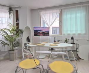 a dining room with a white table and chairs at Golden Stay in Chuncheon