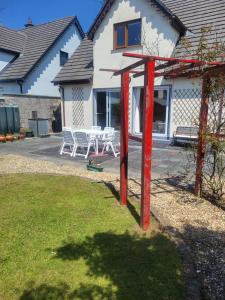 a house with a table and chairs in a yard at Sandy Shore in Ballymoney Cross Roads