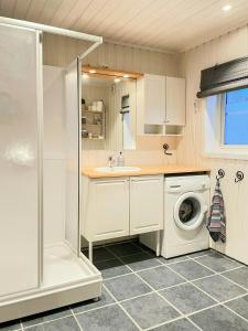 a bathroom with a washing machine and a washer at Seaside Cabin With Fjord Views In Skjerstad in Skjerstad
