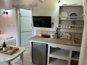 a kitchen with a counter with a tv on the wall at Rodakas Rooms-Glikeria in LivadhokhÃ³rion