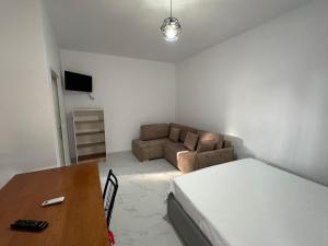 a room with a bed and a couch and a table at Villa Aliaj in Vlorë