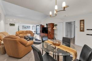 a living room with a glass table and chairs at NEW Pool Home with King Bed Mins to Hospital and Beach in Fort Lauderdale
