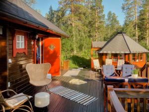 a deck of a cabin with chairs and a gazebo at Log Cabin By Skoddeberg Lake In Tjeldsund in Grovfjord