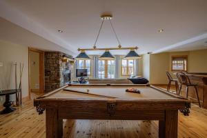a living room with a pool table in it at Forest Getaway, Soak in the Spa, Sauna, Fireplace in Mille-Isles