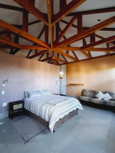 a bedroom with a large bed with a wooden ceiling at Duineveld Self Catering Cottage in Kalkrand