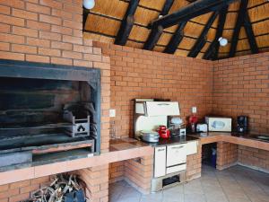 a kitchen with a brick wall with a brick oven at Duineveld Self Catering Cottage in Kalkrand