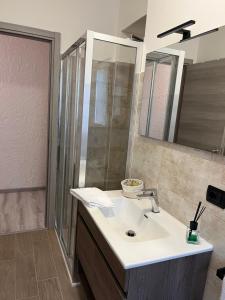 a bathroom with a white sink and a shower at Casa Malù in Valsolda +26 photos