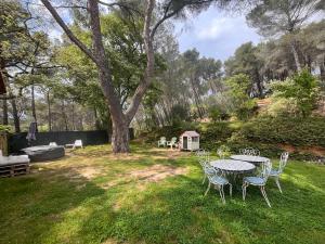 un tavolo e delle sedie in un cortile con un albero di Aix-en-Provence, Maison provençale au calme de la campagne avec Jacuzzi ad Aix en Provence