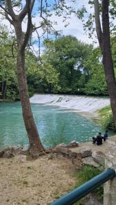 twee mensen zitten aan de oever van een rivier bij Séjour charmant à L'Écrin du Lez in Castelnau-le-Lez