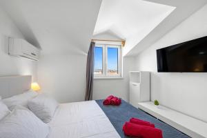 a bedroom with a white bed and a flat screen tv at Holiday home Vodice in Vodice +36 photos