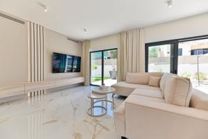 een woonkamer met een bank en een tv bij Villa Perla auf Ciovo in Slatine