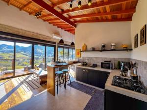 a large kitchen with a view of a mountain at Chalé - Vila Bertina in Gonçalves