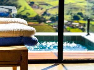 a stack of towels on a table next to a swimming pool at Chalé - Vila Bertina in Gonçalves +14 photos