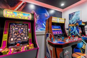 two arcade games in a gaming room with a game at 5BR Getaway with Pool Arcade Games and Resort Access in Davenport
