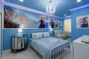 a blue bedroom with a bed and a painting on the wall at 5BR Getaway with Pool Arcade Games and Resort Access in Davenport