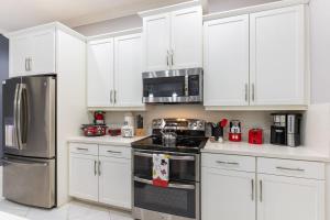 a kitchen with white cabinets and stainless steel appliances at 5BR Getaway with Pool Arcade Games and Resort Access in Davenport +136 photos