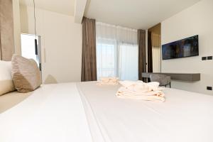 een slaapkamer met een wit bed met handdoeken erop bij Villa Perla auf Ciovo in Slatine +42 foto's