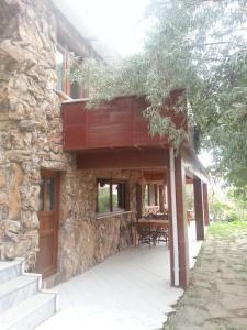 a stone house with a deck and a table at Uysallar Koy Evi in Gokceada Town