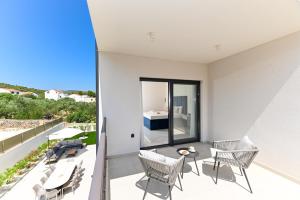 een balkon met stoelen en een tafel en uitzicht op de oceaan bij Villa Perla auf Ciovo in Slatine