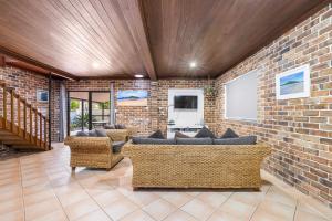 a living room with couches and a brick wall at Sandy Feet at Hat Head - No Sheets or Towels Provided in Hat Head