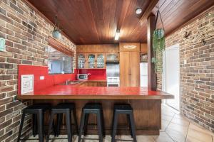 a kitchen with a bar with stools around it at Sandy Feet at Hat Head - No Sheets or Towels Provided in Hat Head
