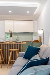 een woonkamer met een bank en een keuken bij Séjour charmant à L'Écrin du Lez in Castelnau-le-Lez