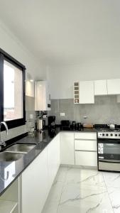 a kitchen with white cabinets and a sink at Estrada in Bahía Blanca