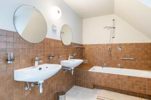 a bathroom with two sinks and a tub and mirror at Villa Gloria in Ostend +25 photos